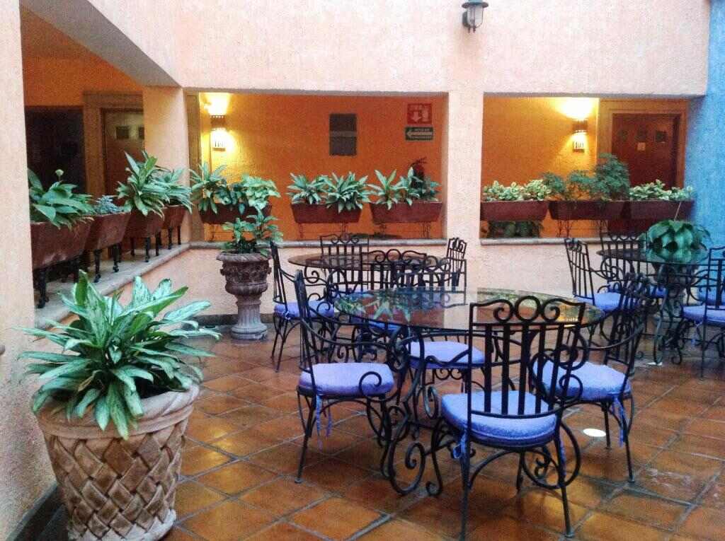 Covered hotel patio with wrought iron seating